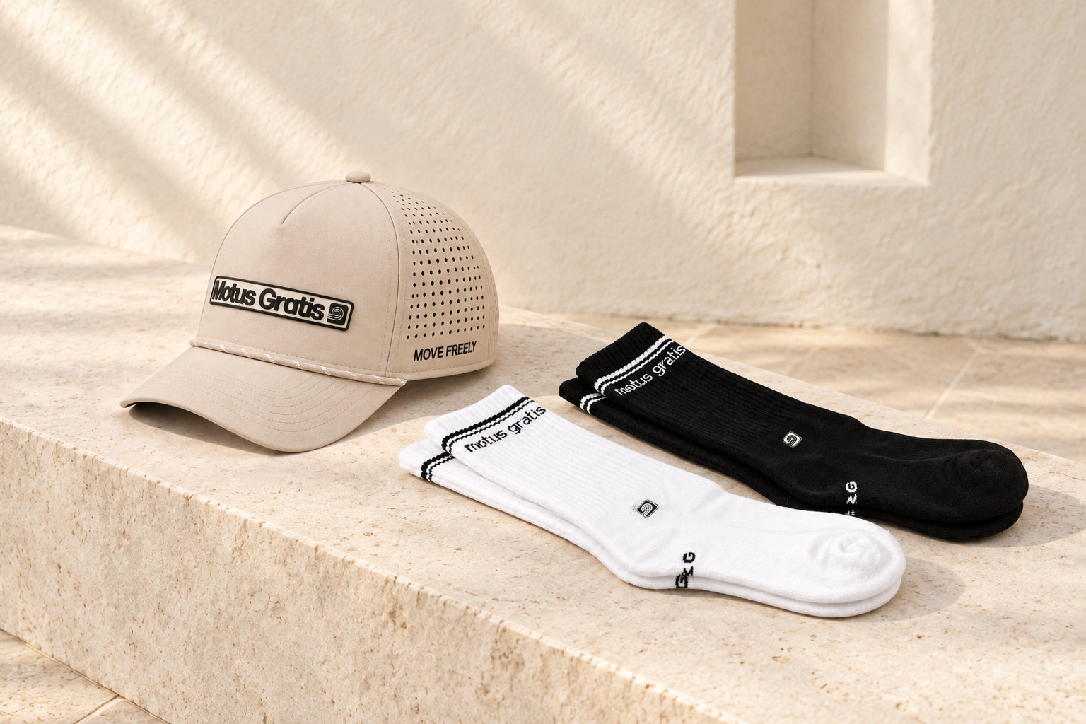 Bone Versa cap with black and white Gradus socks on a sunlit stone plinth.