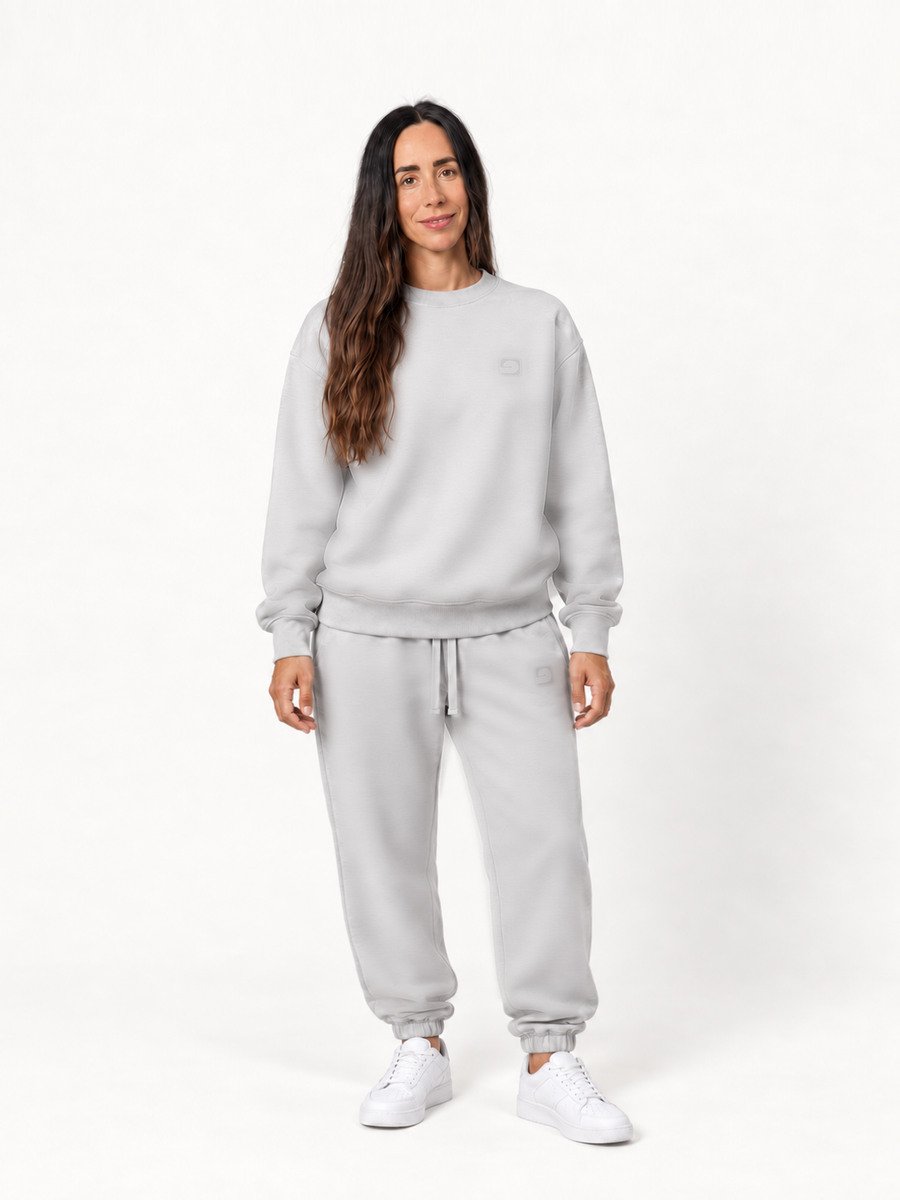 Women's gray Infinitum sweatshirt and Pura sweatpants on a smiling fashion model