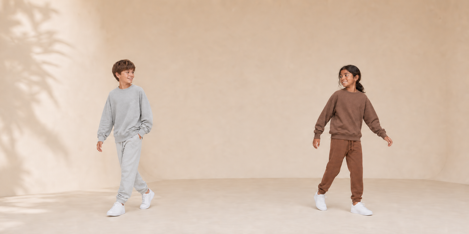 Motus Gratis youth collection with boy in gray and girl in brown coordinated sets, desktop hero