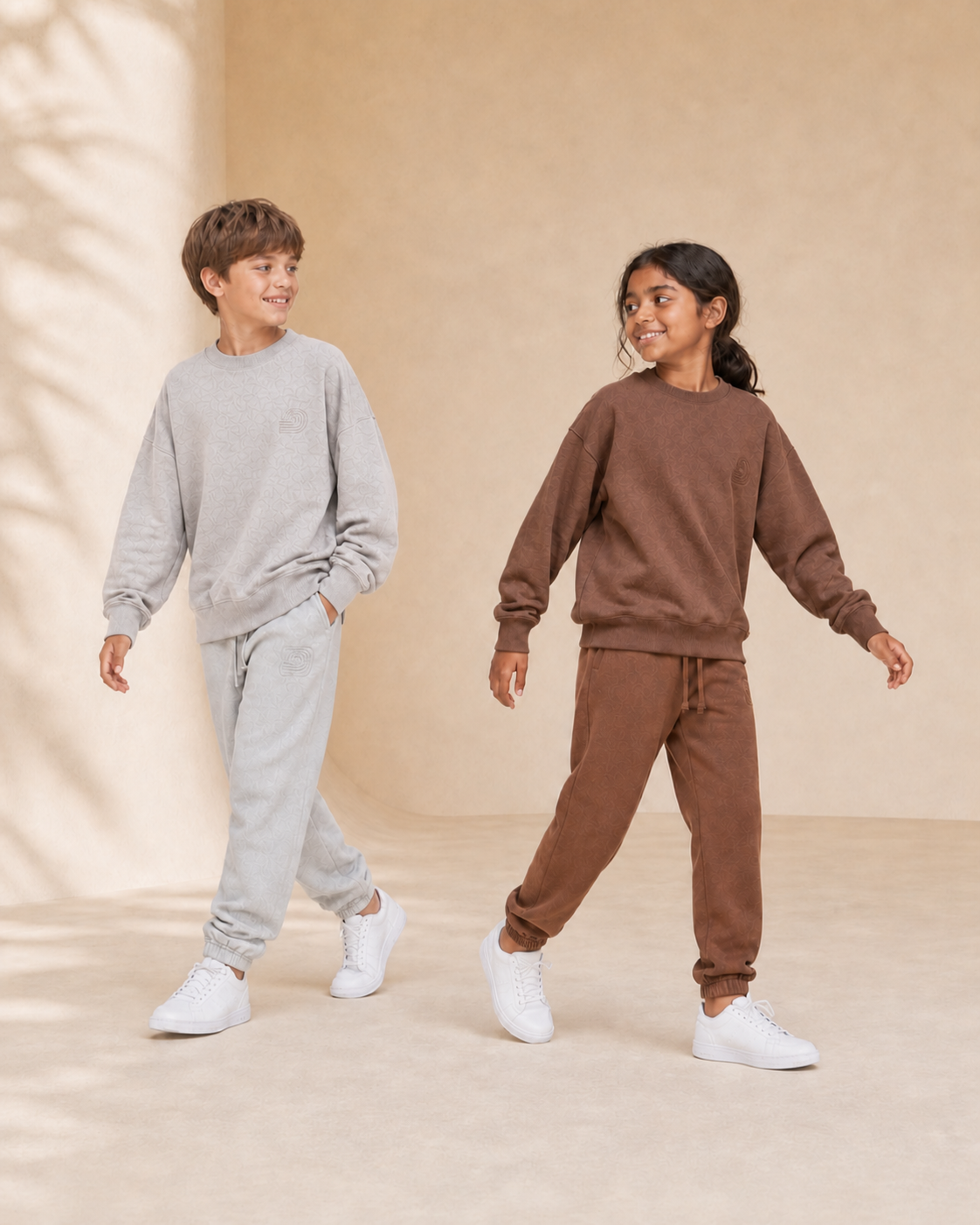 Motus Gratis youth collection with boy in gray and girl in brown coordinated sets, mobile hero